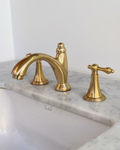 Gold faucet and handles on a marble sink