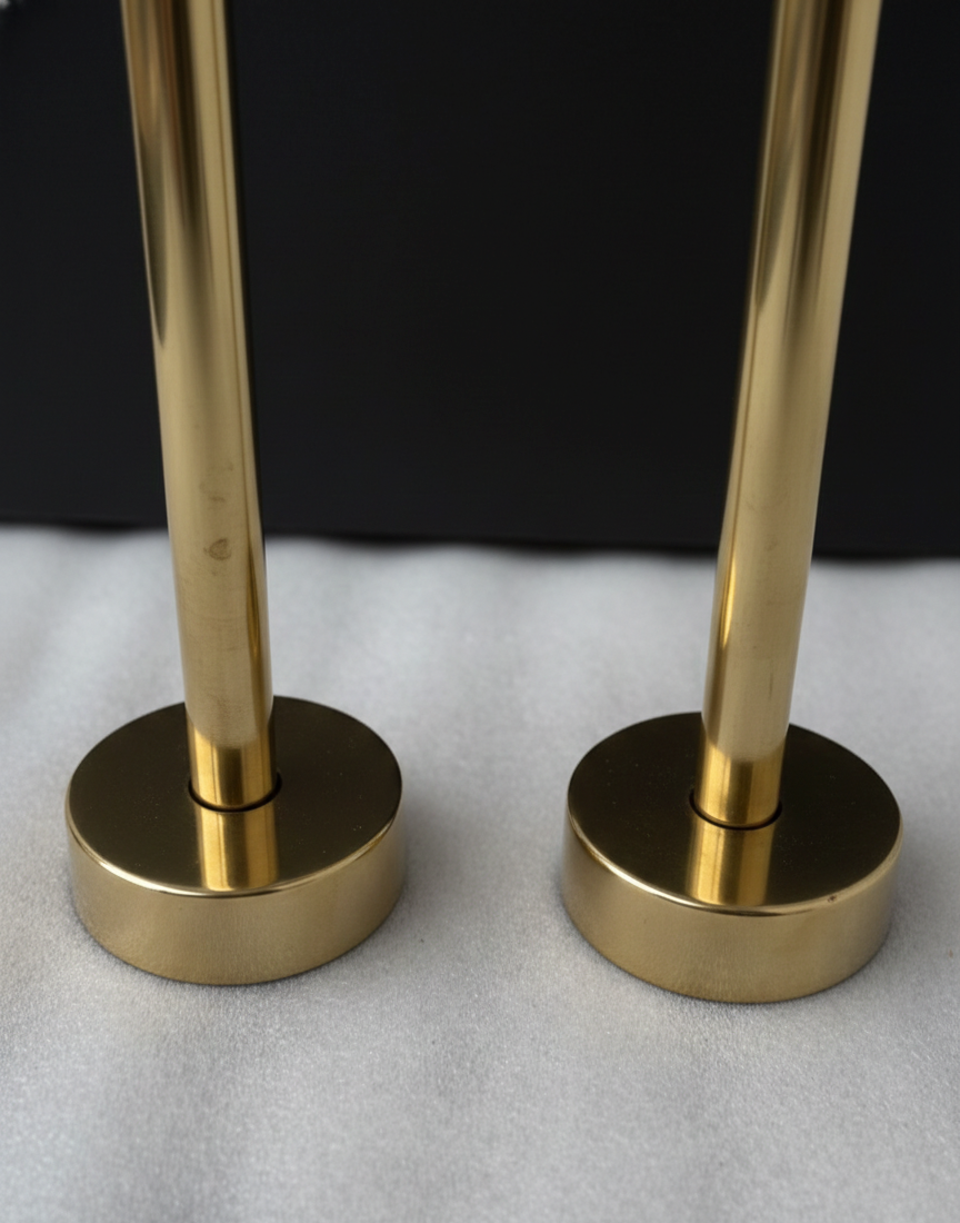 Two gold towel racks on a white surface with a black background