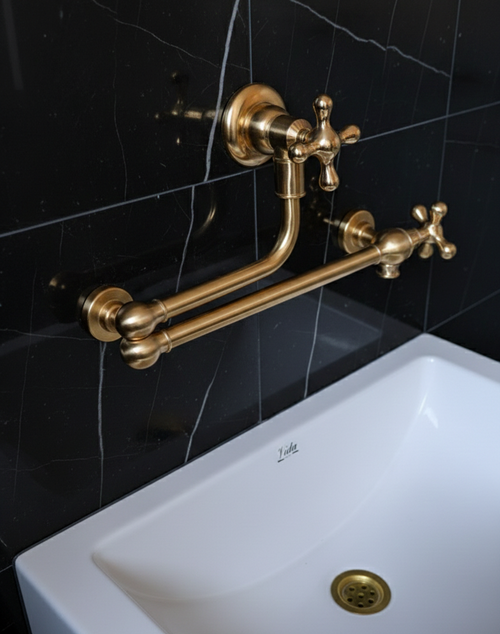 brass faucet and handles on a white sink against a black tiled wall