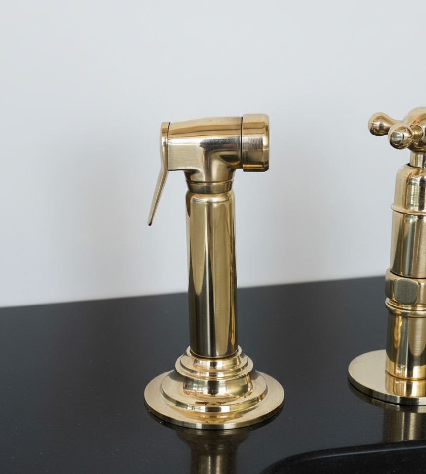 Gold bathroom faucet on a reflective surface with a light gray background
